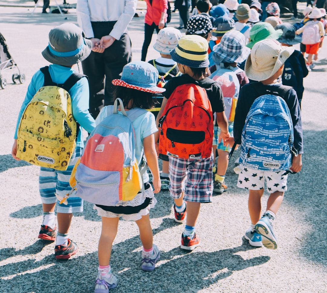 group-of-people-wearing-white-and-orange-backpacks-walking-on-gray-concrete-pavement-during-daytime-cylpykf-qam